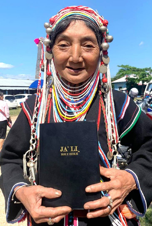 An Akha sister holding an Akha Bible